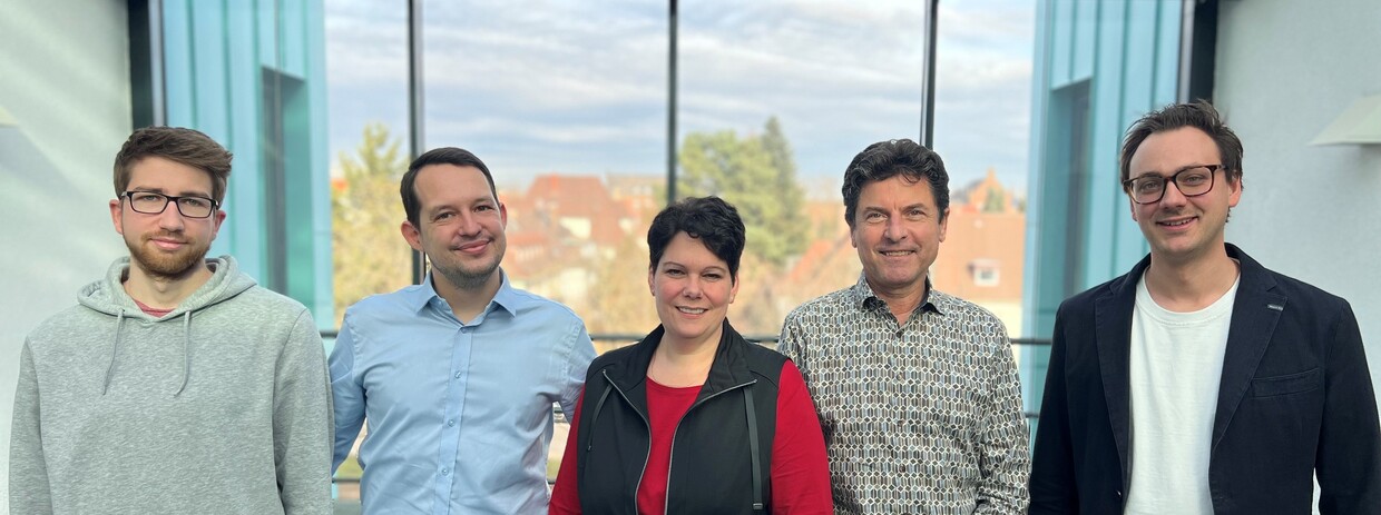 Mitarbeiter des Lehrstuhls für Wirtschaftstheorie mit überdimensionierten Hüten